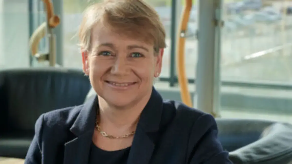 headshot of Anne Marie smiling in front of bright blurred window