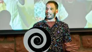 Dr Adrian Garcia Burgos from Science Is Magic performs a routine, with a digital screen in the background