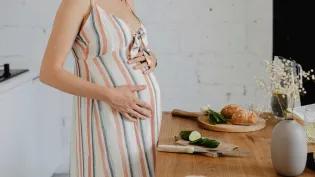 pregnant person chopping bread and vegetables