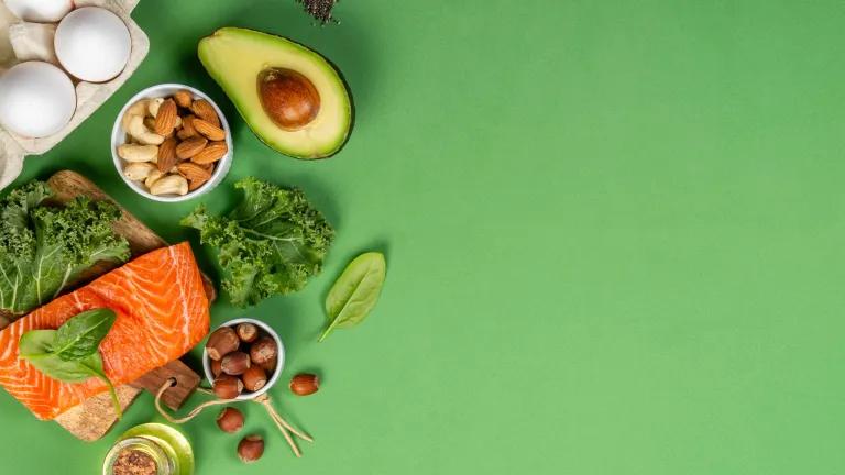 avocado, vegetables and salmon on a green background