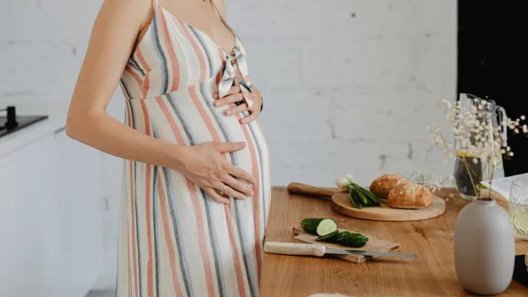 pregnant person chopping bread and vegetables