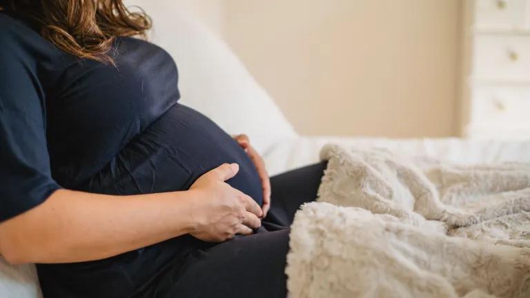 Prgnant woman sitting down holding her belly