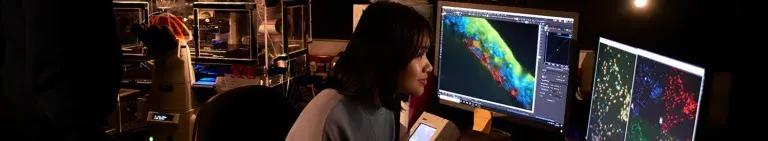 Researcher working at multi-coloured computer monitors