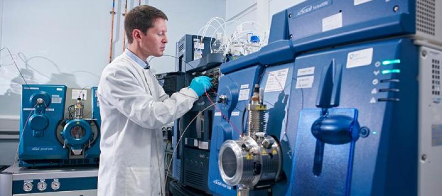 Researcher in a lab with mass spectrometry