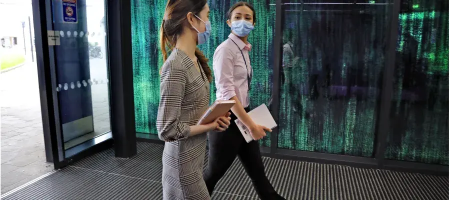Students and staff walking in a corridor at Little France