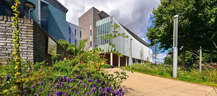 Exterior of Institute of Genetics and Cancer with flowers in foreground