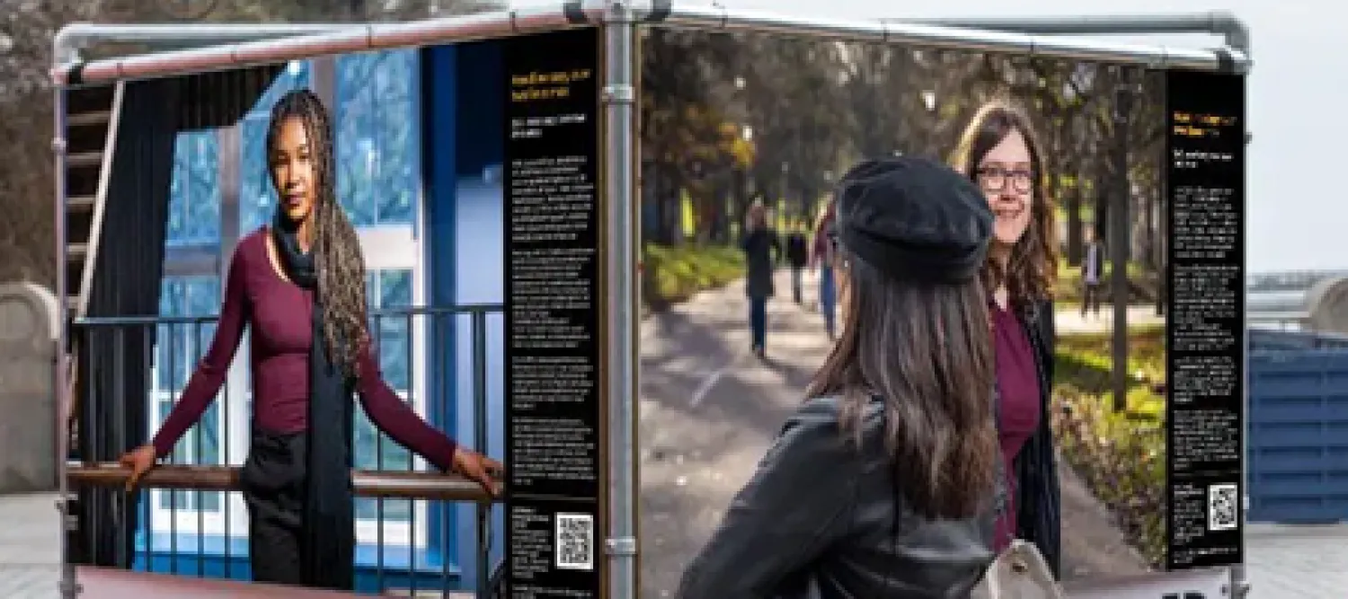 Exhibition cubes displaying photography and a person viewing them in the foreground.