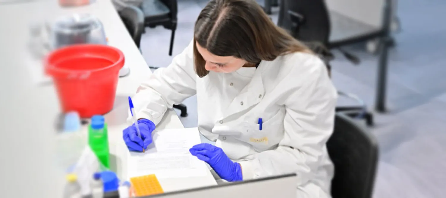 Person sitting in the lab taking notes