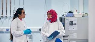 Clinical researchers talking in lab coats