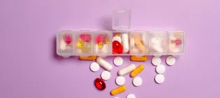 A collection of pills falling out of a pill box