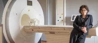 Professor Wardlaw with one of the Univresity's research Magnetic Resonance Scanners.