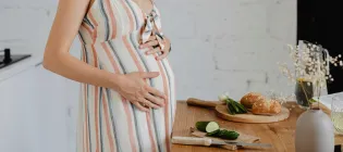 pregnant person chopping bread and vegetables