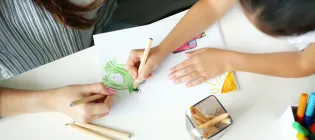 birdseye view of a child and therapist drawing pictures on some paper