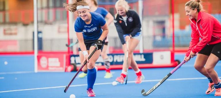 Students playing hockey at pefermill pitches