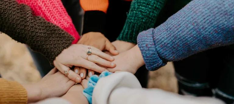 Team of hands in the middle of a circle