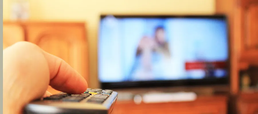 Remote control in foreground, tv in background