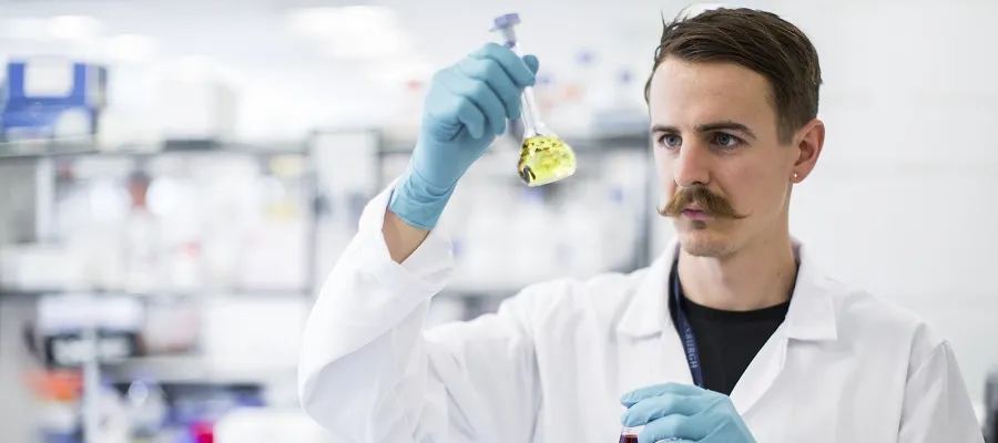 An Optima researcher examines a specimen