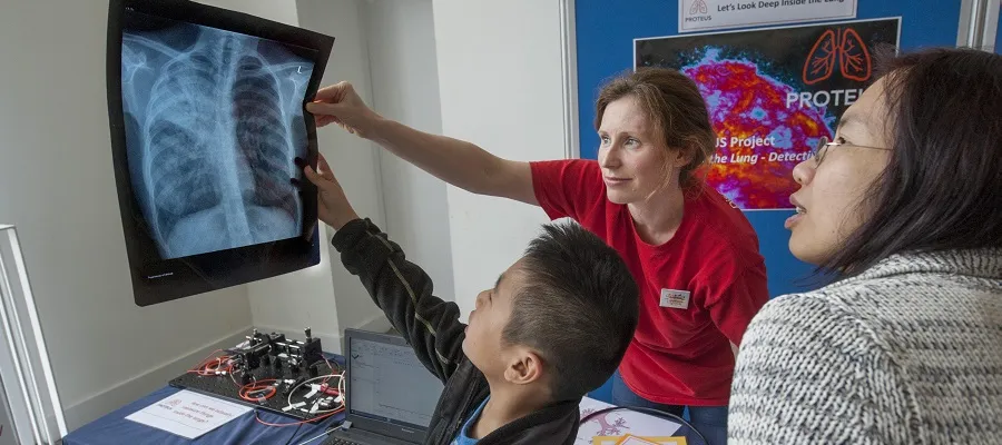 Researcher explains image to visitors at Edinburgh International Science Festival