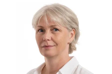 Dawn Livingstone headshot, smiling in a white collared shirt, on a white background