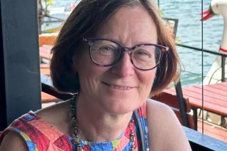 Karen Chapman, smiling sitting outside