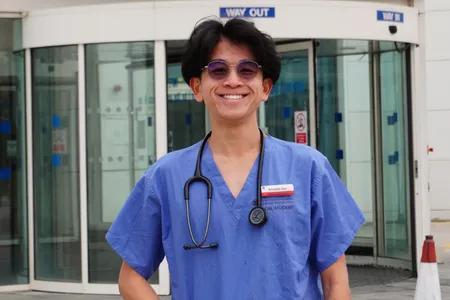 Shot of Krisada, wearing sunglasses and dressed in medical scrubs