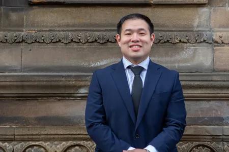 Portrait of Solomon, wearing a suit against neutral background