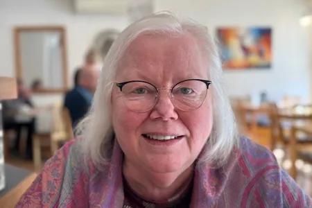 Head shot of Fanney, with cafe in background