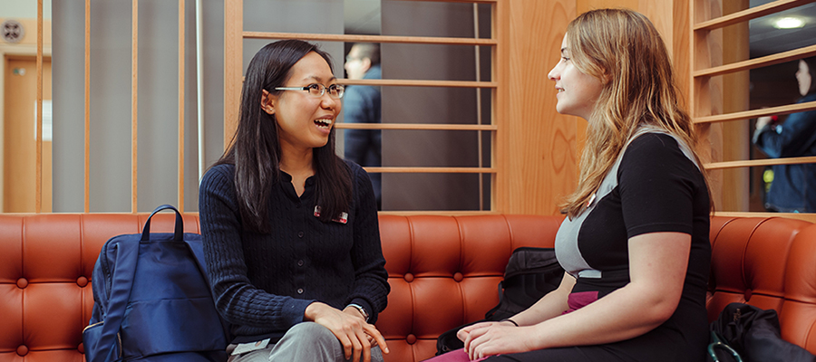 Two students sitting in the Chancellors Building having a conversation