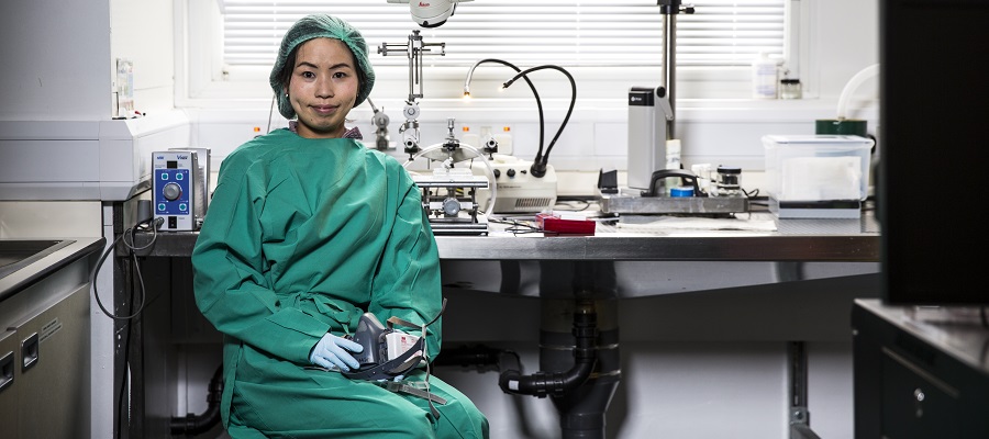 A researcher wears laboratory protective gear