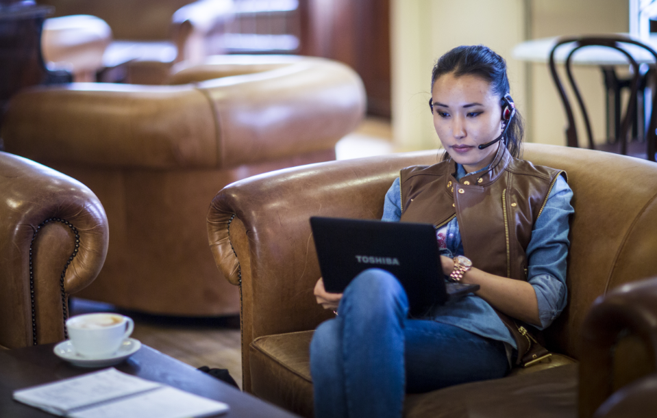 online learning student sat at laptop with headset