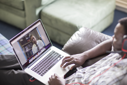 online student sat at laptop with headset